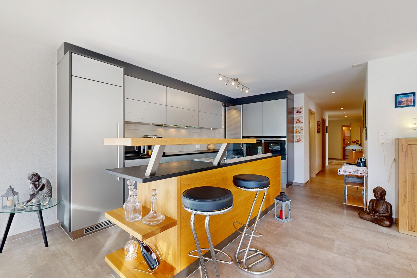 cuisine avec bar de cuisine, armoires grises, cloison sèche, drywall, et inside property