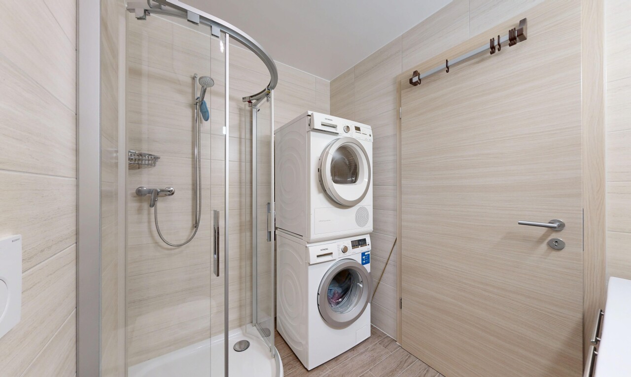 salle de bains avec salle de bain complète, douche, lave-linge et sèche-linge superposés, et inside property