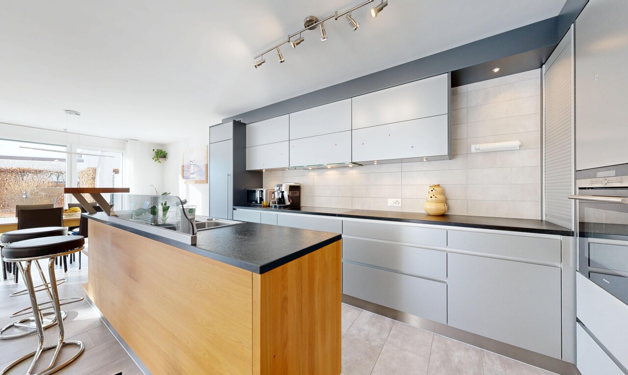 cuisine avec îlot de cuisine, dosseret, backsplash, inside property, et armoires à panneau plat