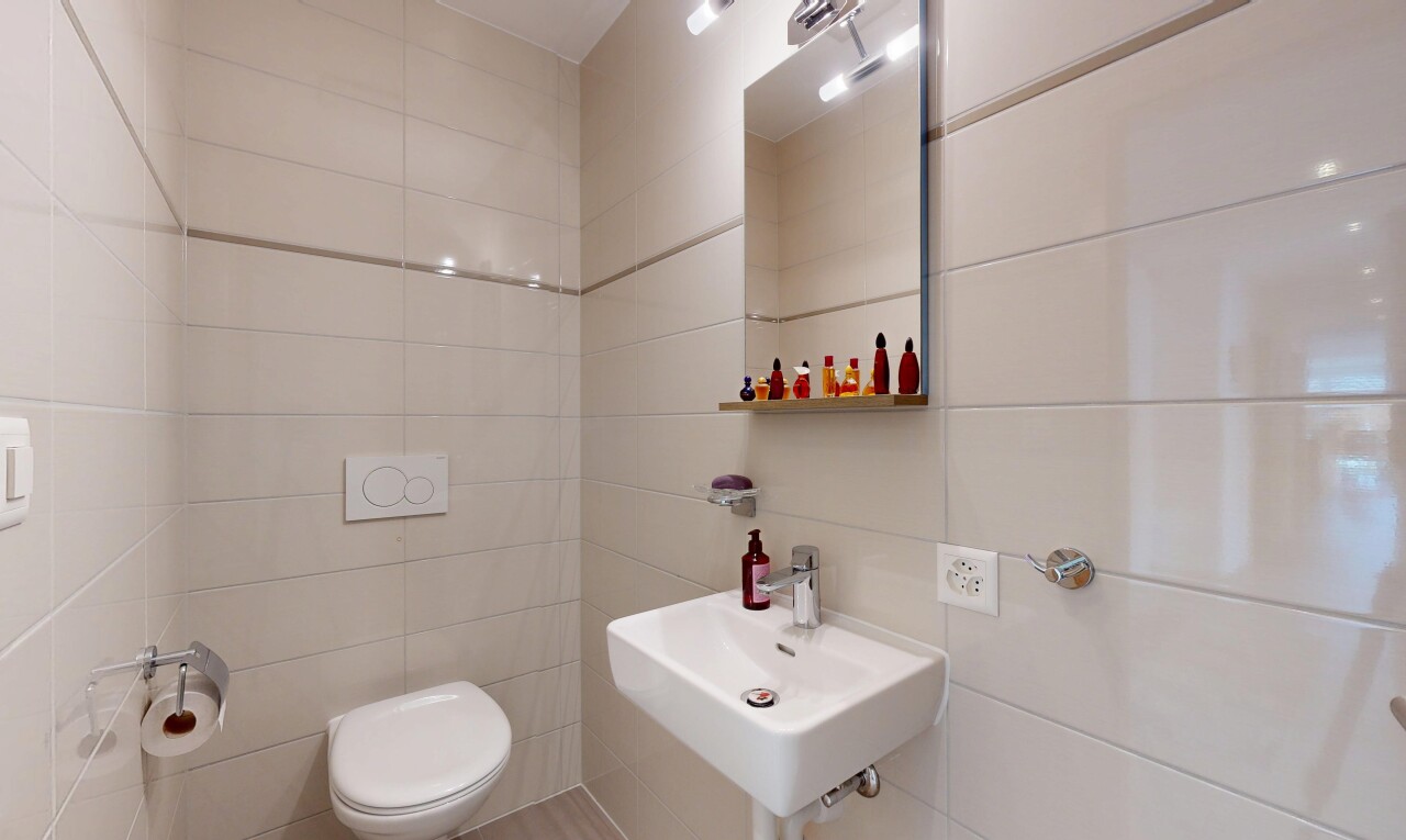 salle de bains avec toilette, miroir, inside property, mur en carrelage, et tile wall