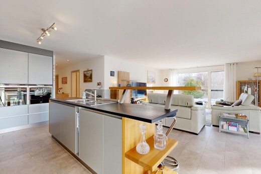 kitchen featuring open floor plan, a kitchen island with sink, dark countertops, and stainless steel oven