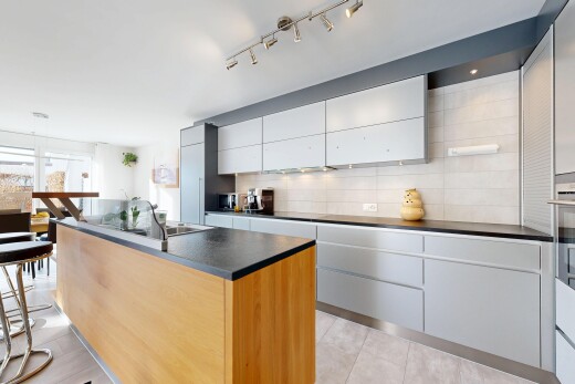 kitchen with a center island with sink, backsplash, modern cabinets, dark countertops, and white cabinets