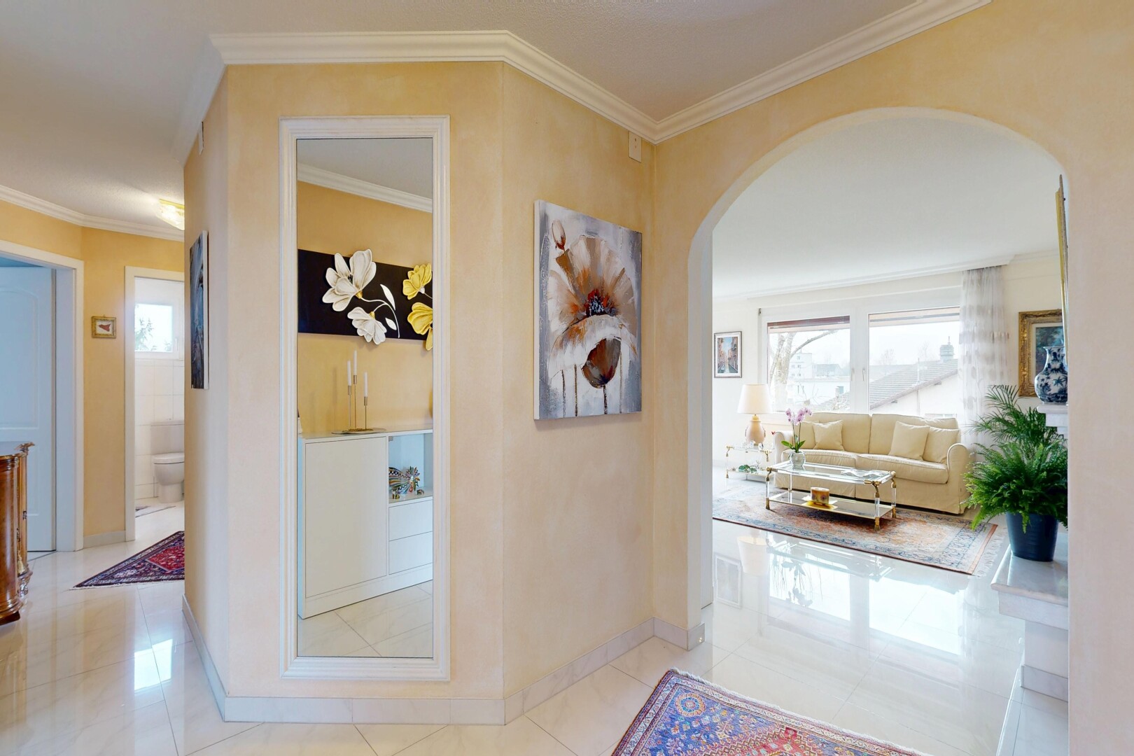hallway featuring ornamental molding, arched walkways, and light tile patterned flooring