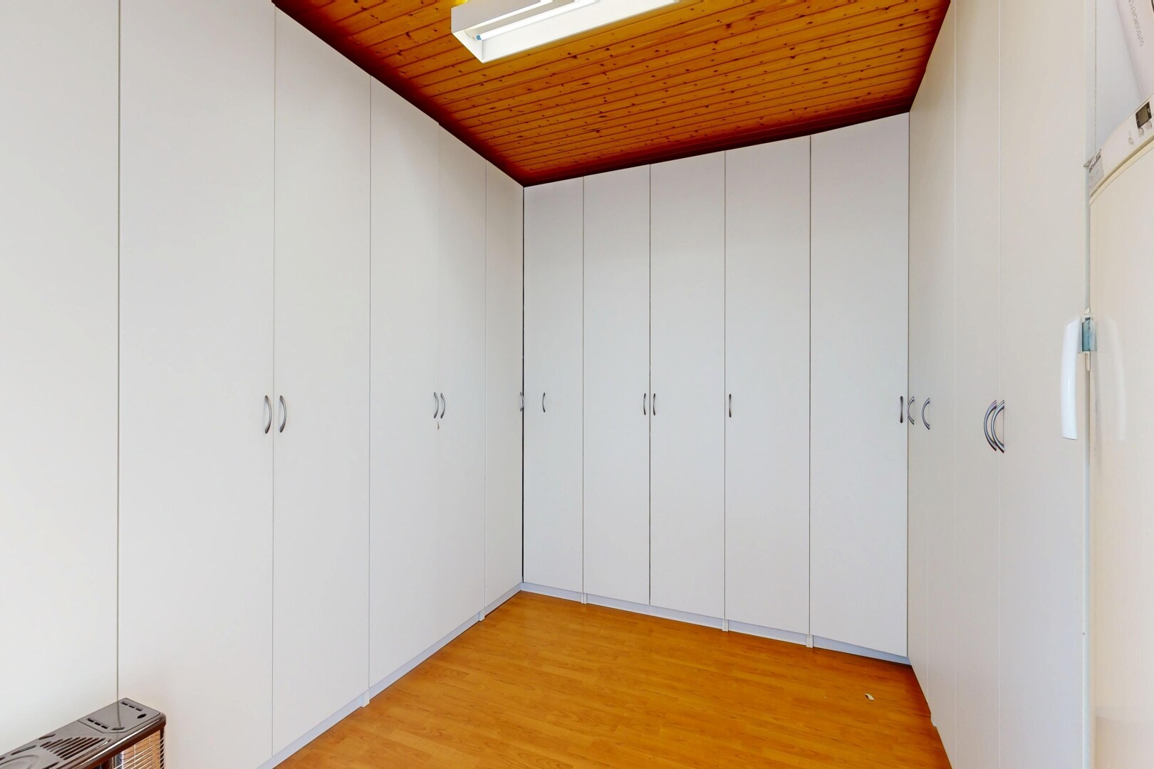 unfurnished room with light wood-style flooring and freestanding refrigerator