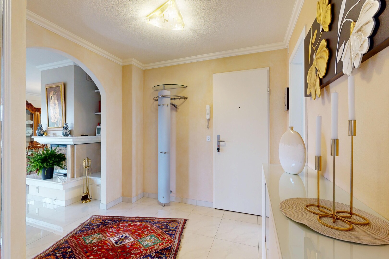 hall with crown molding, arched walkways, and built in shelves