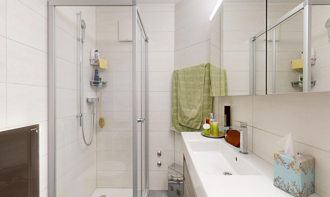 bathroom with a stall shower, tile walls, and vanity