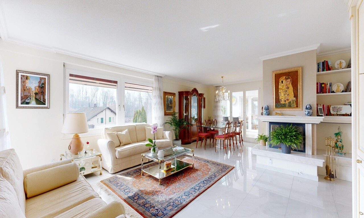 living / dining area with hanging lights, crown molding, and a fireplace