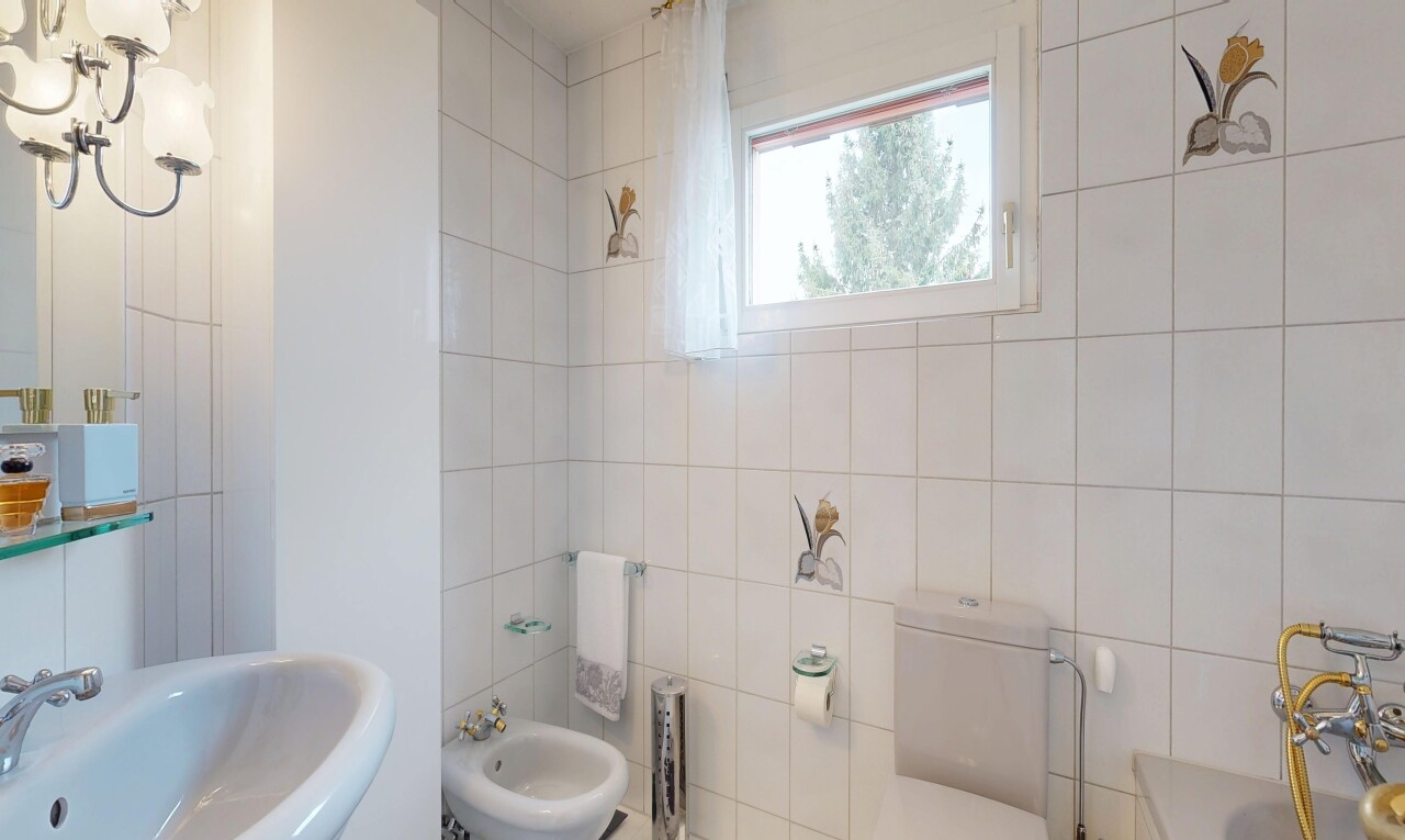 full bath with a bidet, tile walls, and a tub to relax in