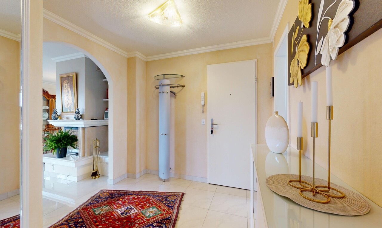 hall with crown molding, arched walkways, and built in shelves