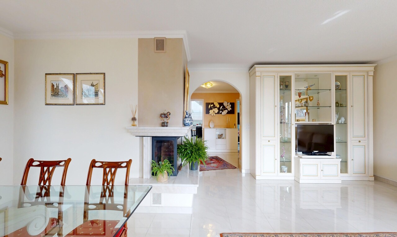 dining room with arched walkways, crown molding, light tile patterned floors, and a fireplace