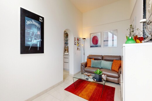 wohnzimmer mit gewölbte gehwege, drywall, gipskartonwand, inside property, und tile floor