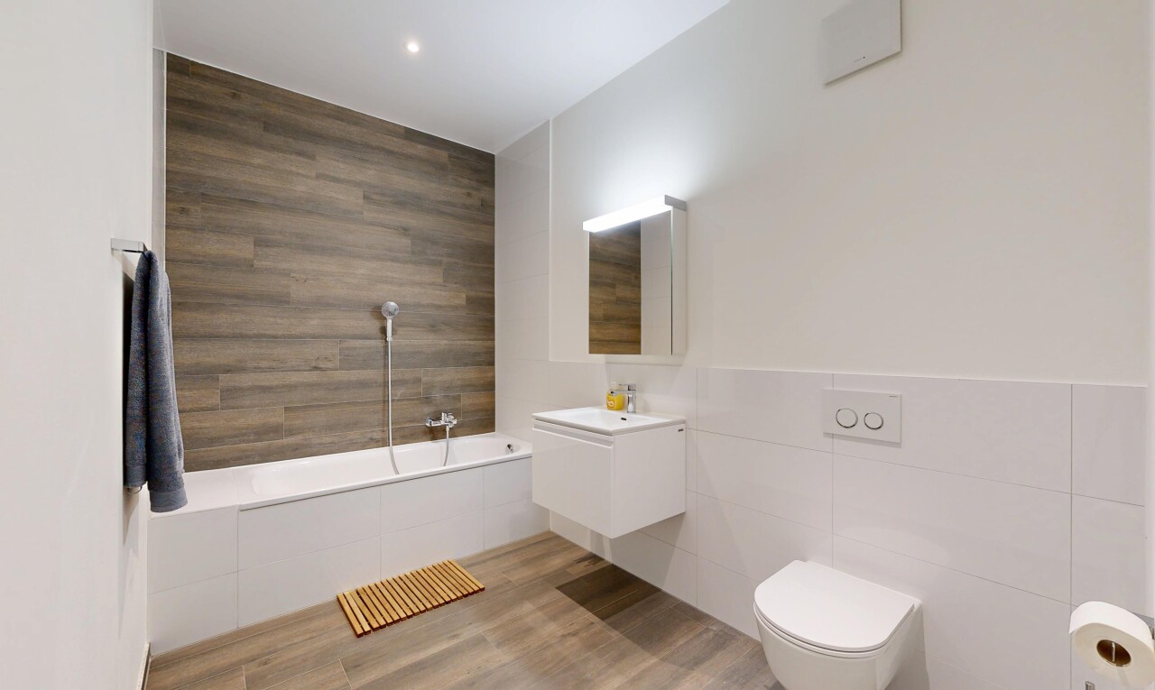salle de bains avec tile wall, mur en carrelage, salle de bain complète, lavabo (ou coiffeuse selon le contexte), et miroir
