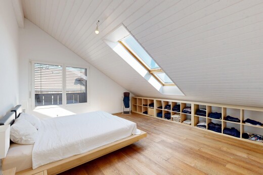 chambre avec vaulted ceiling, plafond voûté, puits de lumière, étagères intégrées, et lumière naturelle