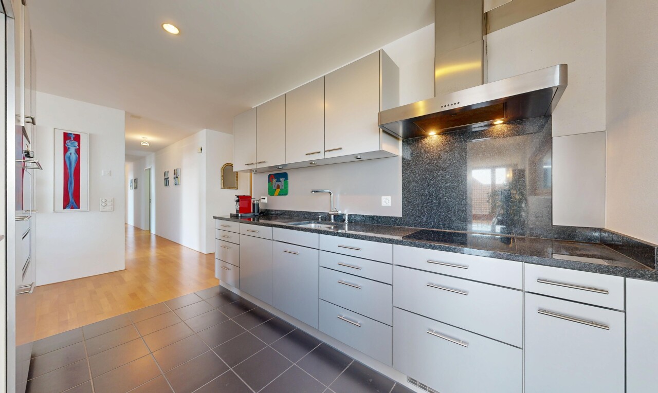 cuisine avec hotte, dark countertops, cloison sèche, drywall, et inside property