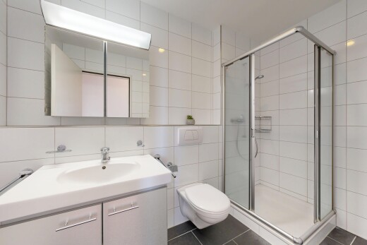full bath featuring tile walls, a shower stall, vanity, and dark tile patterned floors