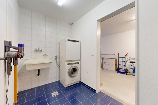 laundry room featuring washer / dryer, tile walls, and dark tile patterned floors
