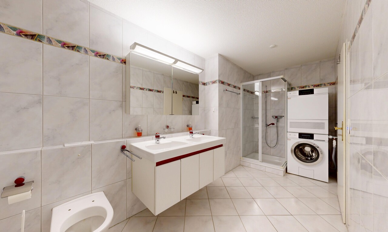 salle de bains avec mur en carrelage, tile wall, double vasque, light floor, et salle de bain complète