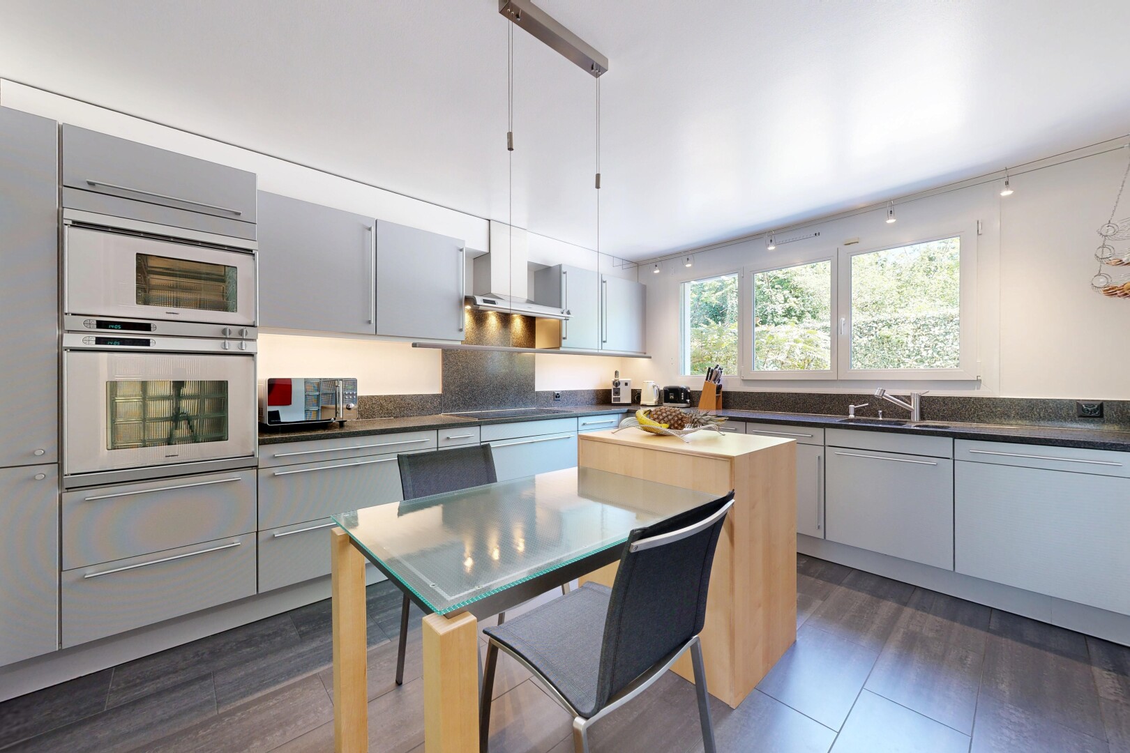 cuisine avec dark countertops, dark floor, four, wood finish floor, et sol en finition bois