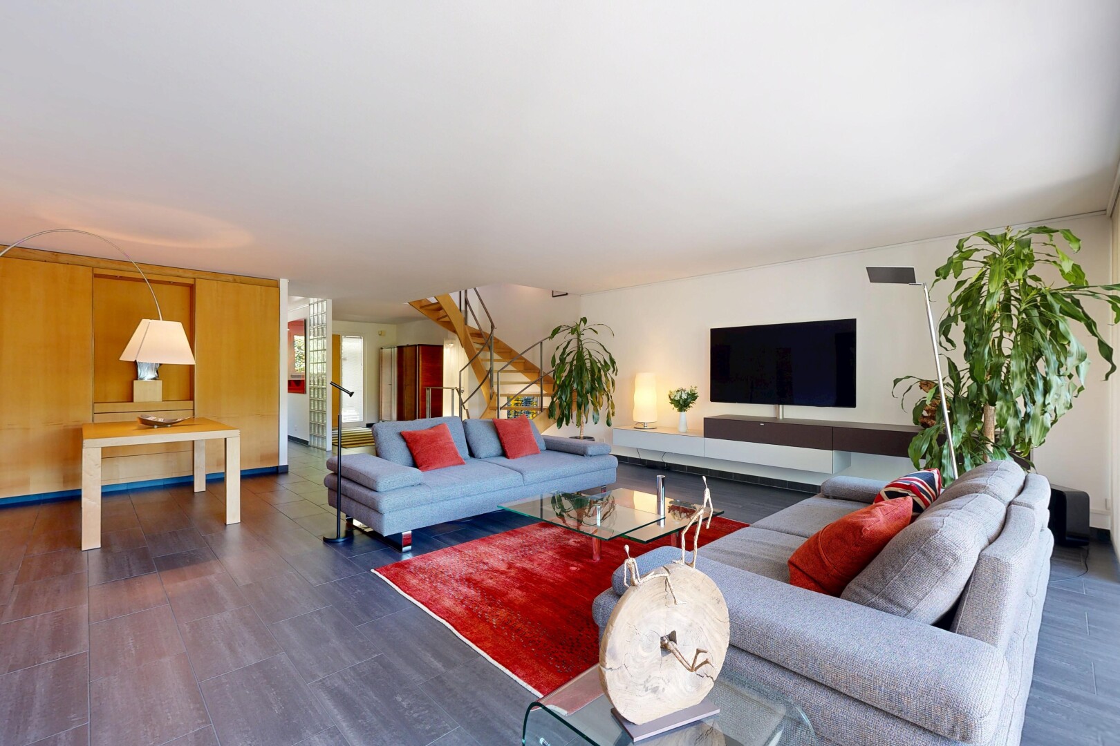 salon avec wood finish floor, sol en finition bois, inside community, télévision, et drywall
