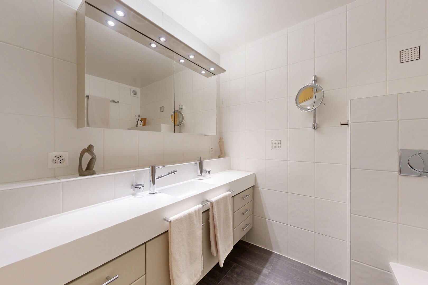 salle de bains avec lavabo (ou coiffeuse selon le contexte), mur en carrelage, tile wall, dark floor, et salle de bain complète