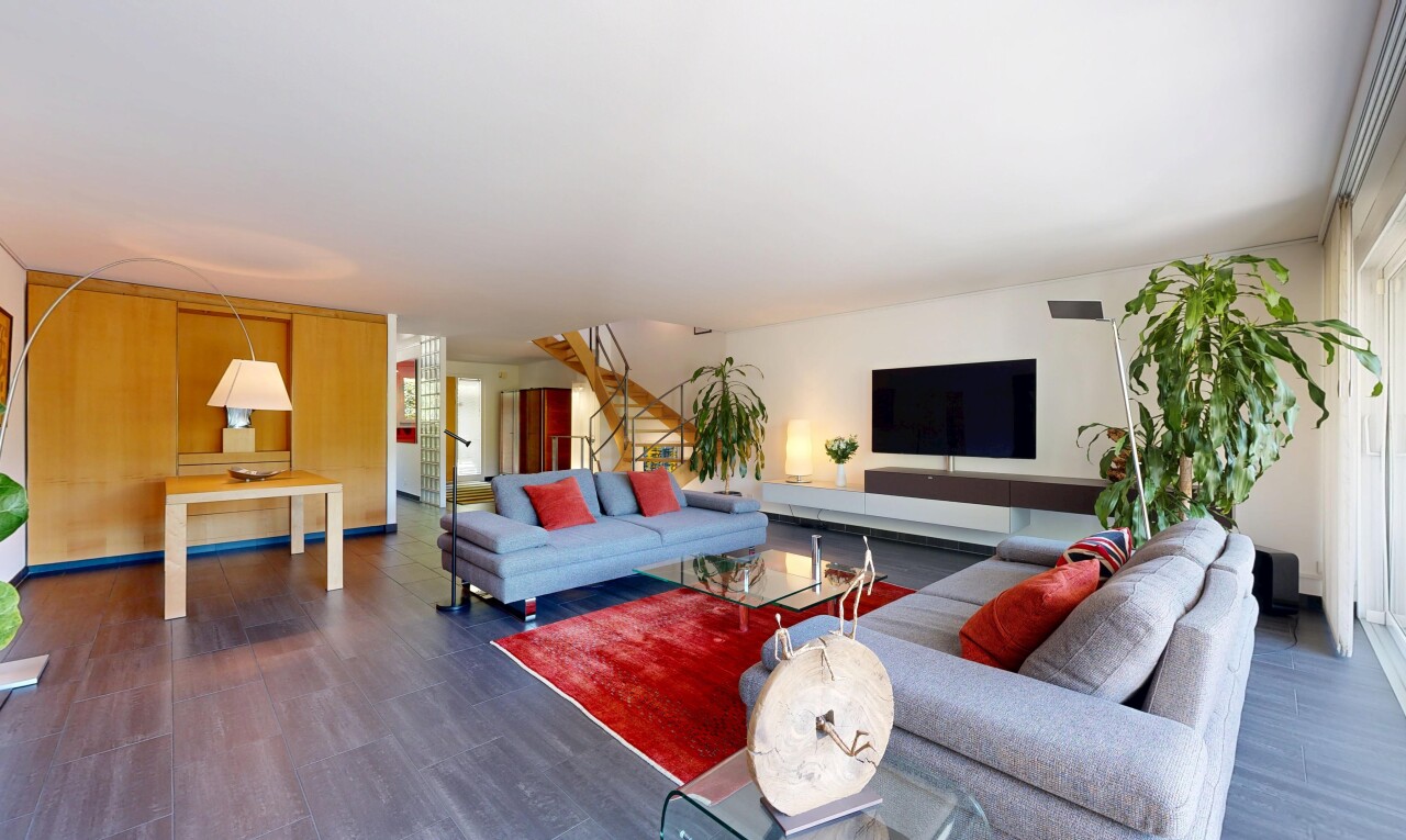 salon avec wood finish floor, sol en finition bois, inside community, télévision, et drywall
