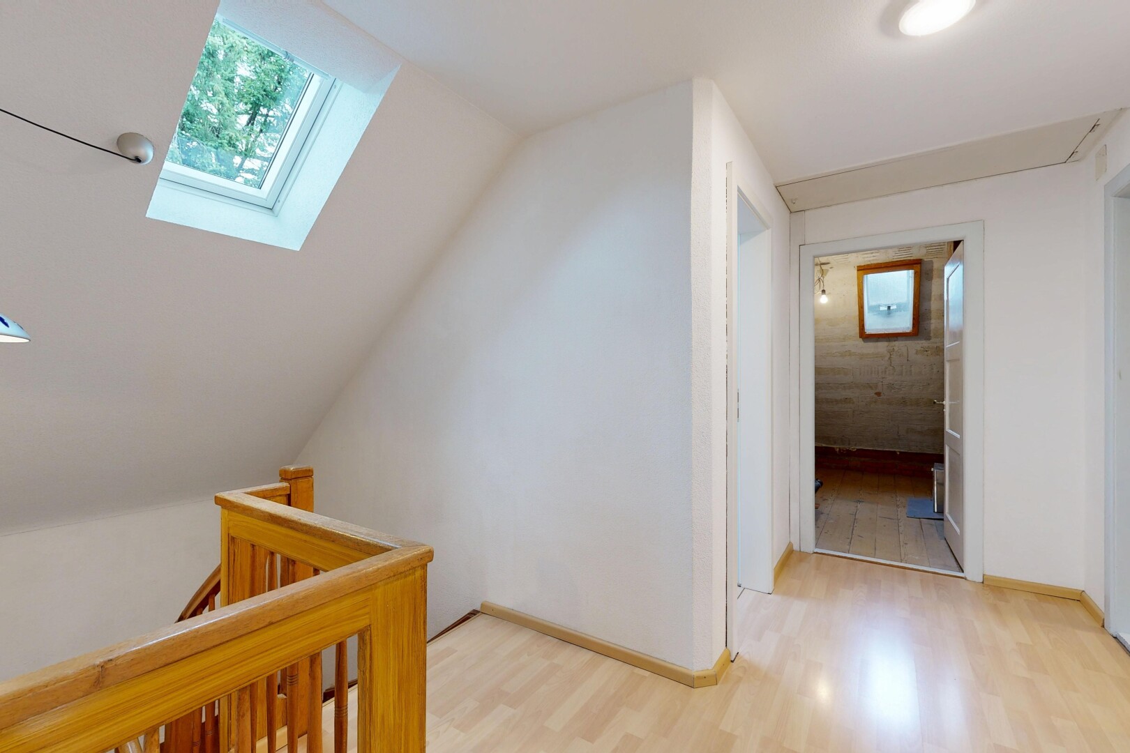halle / korridor mit wood finish floor, holzfußboden, dachfenster, inside property, und drywall