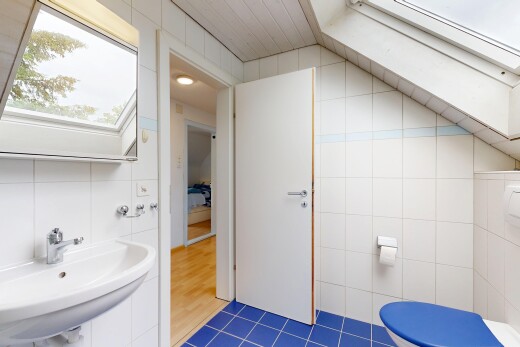 half bathroom with tile walls and dark tile patterned floors