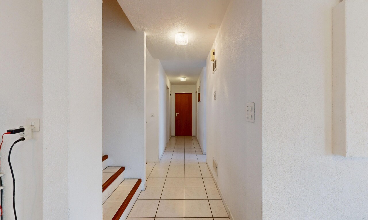couloir avec tile floor, sol en carrelage, inside property, light floor, et drywall