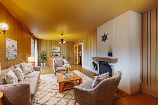 wohnzimmer mit kamin, holzfußboden, sockelleisten, bemerkenswerter kronleuchter, und natürliches licht