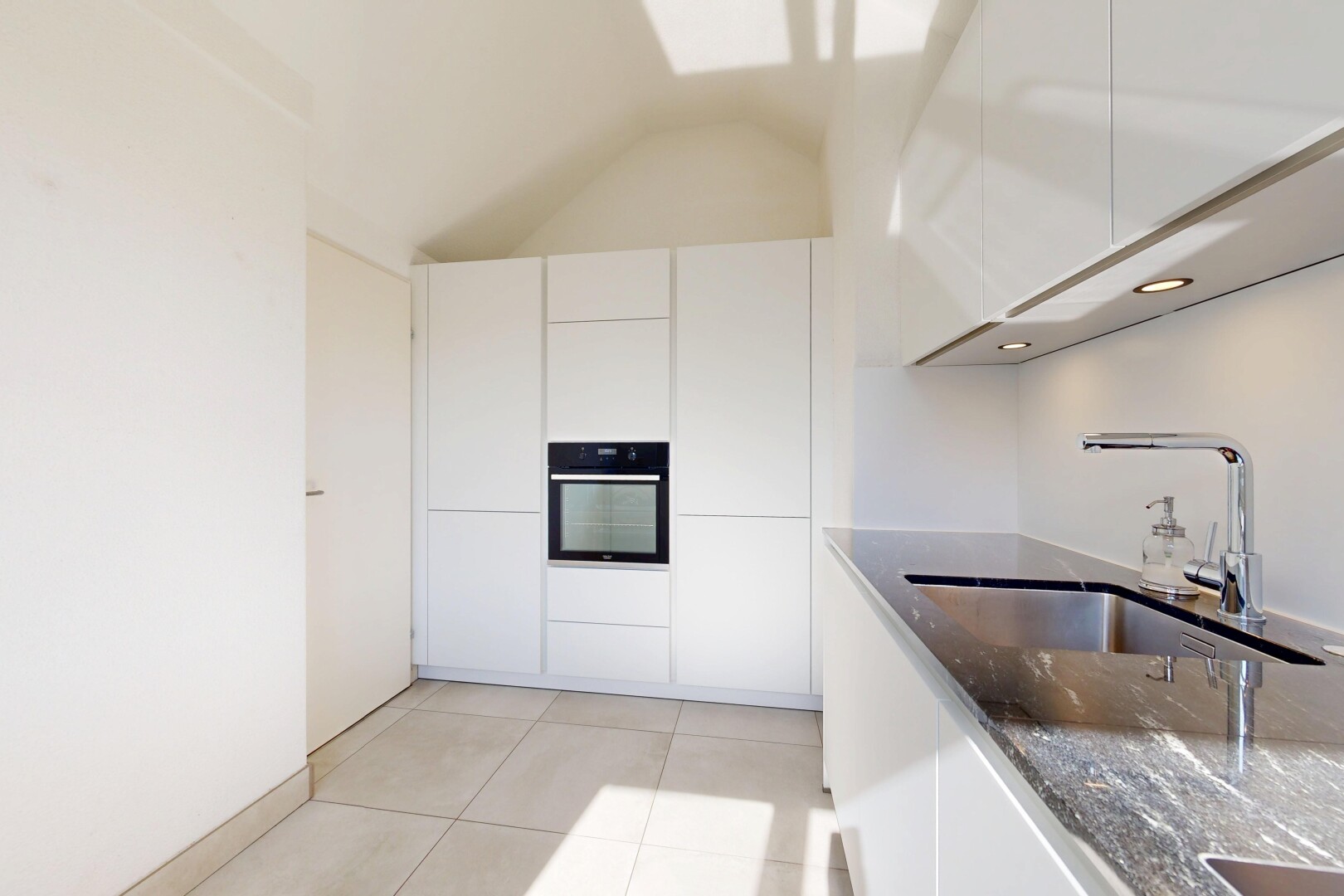 cuisine avec four, évier, light floor, armoires blanches, et white cabinets