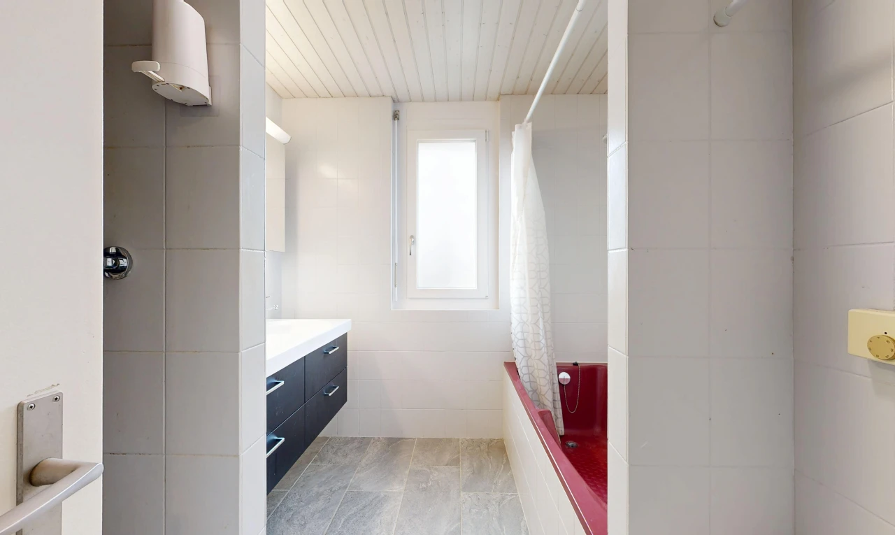 full bath featuring tiled shower / bath combo, vanity, and tile walls