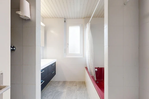 full bath featuring tiled shower / bath combo, vanity, and tile walls