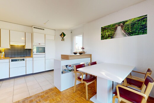 kitchen with breakfast area, white cabinetry, light countertops, and oven