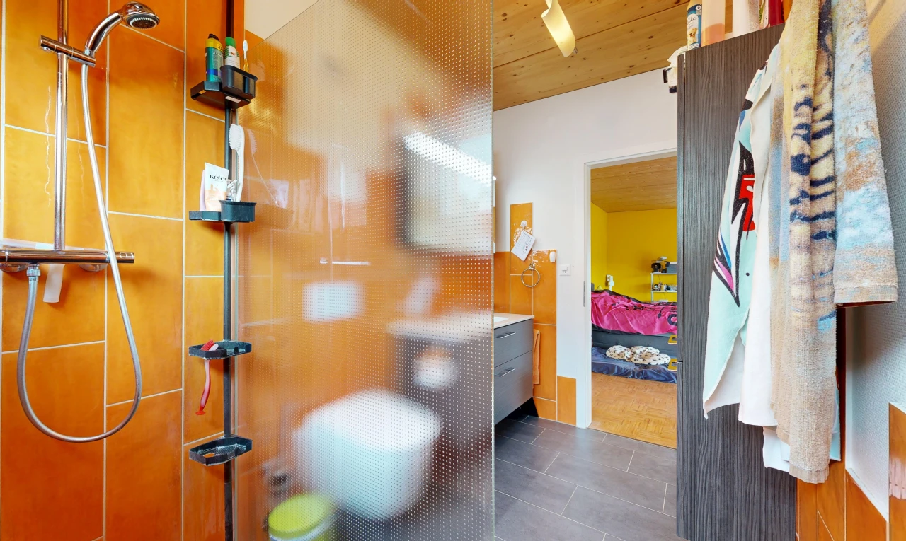 ensuite bathroom with a tile shower and wooden ceiling