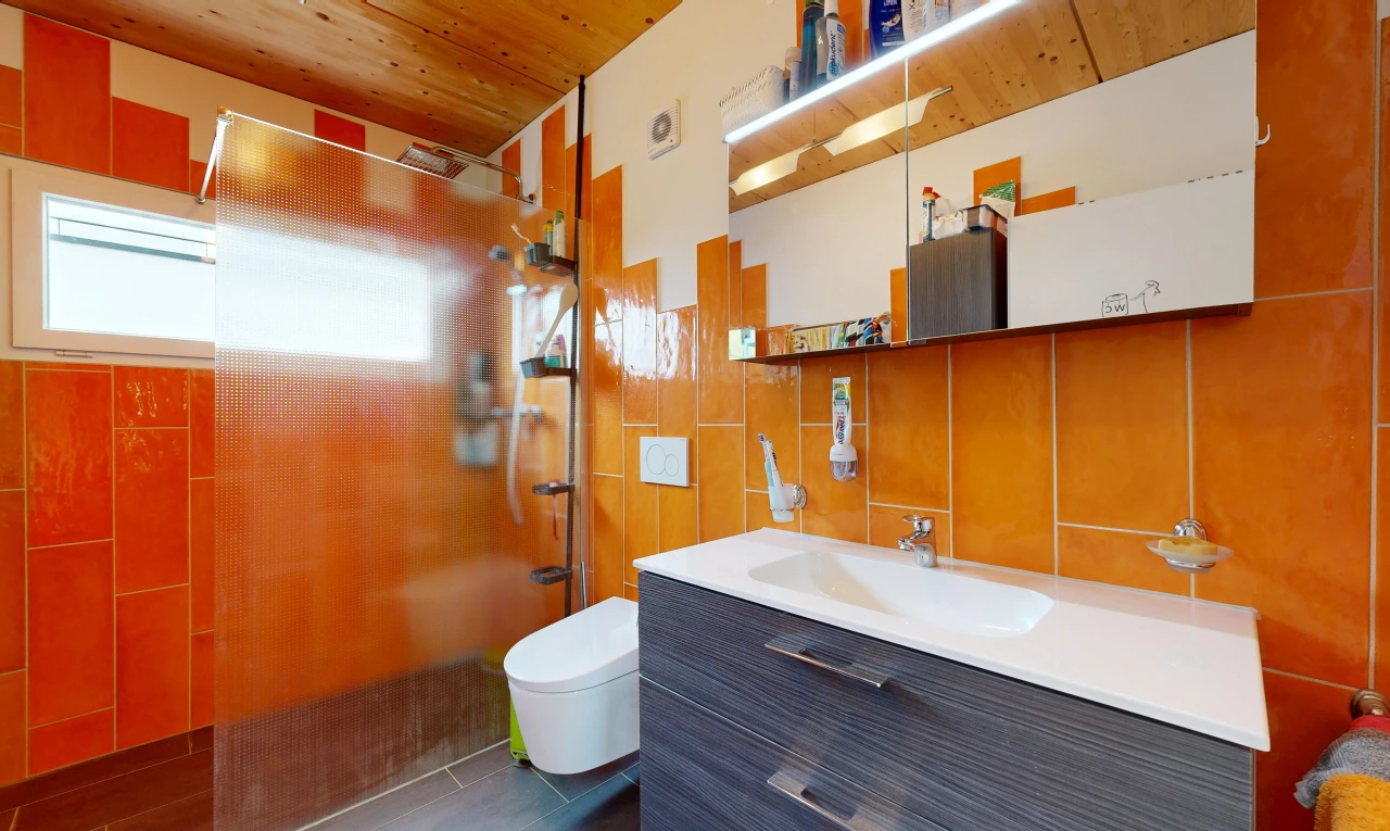 full bath with a tile shower, vanity, wood ceiling, and tile walls