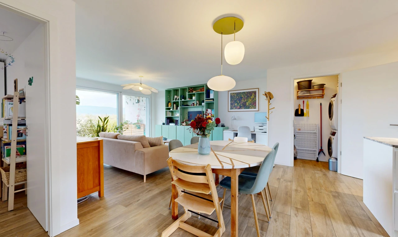 salon / salle à manger avec étagères intégrées, lave-linge et sèche-linge superposés, sol en finition bois, wood finish floor, et cloison sèche