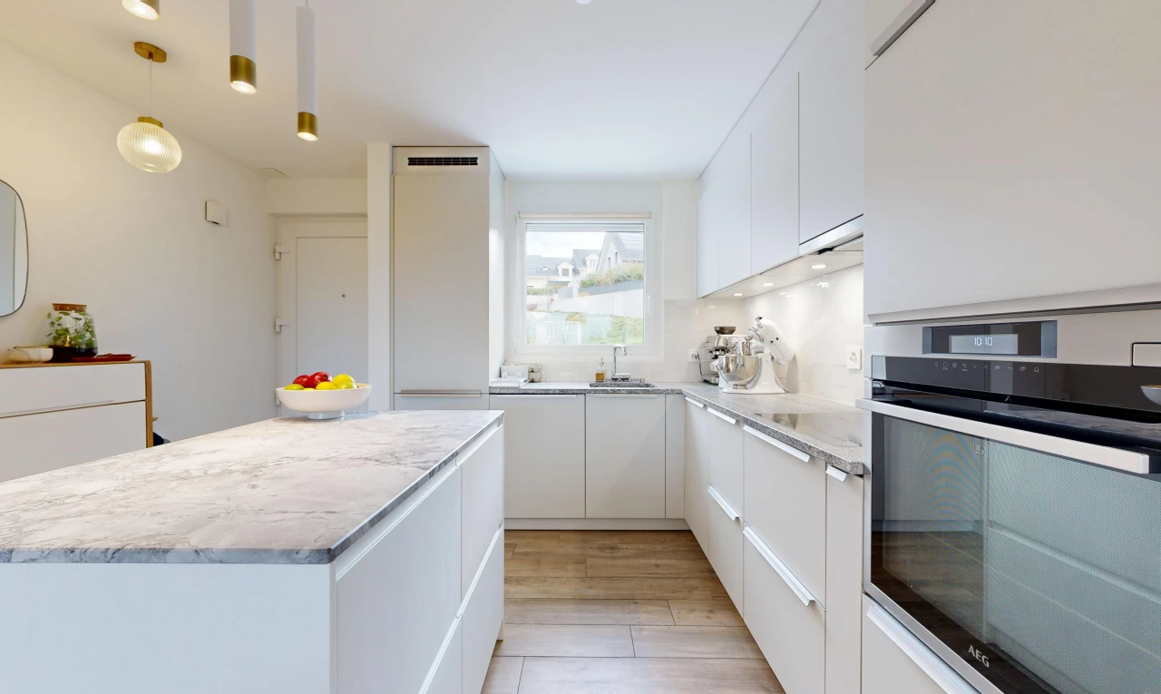 cuisine avec four, light countertops, light floor, armoires blanches, et white cabinets
