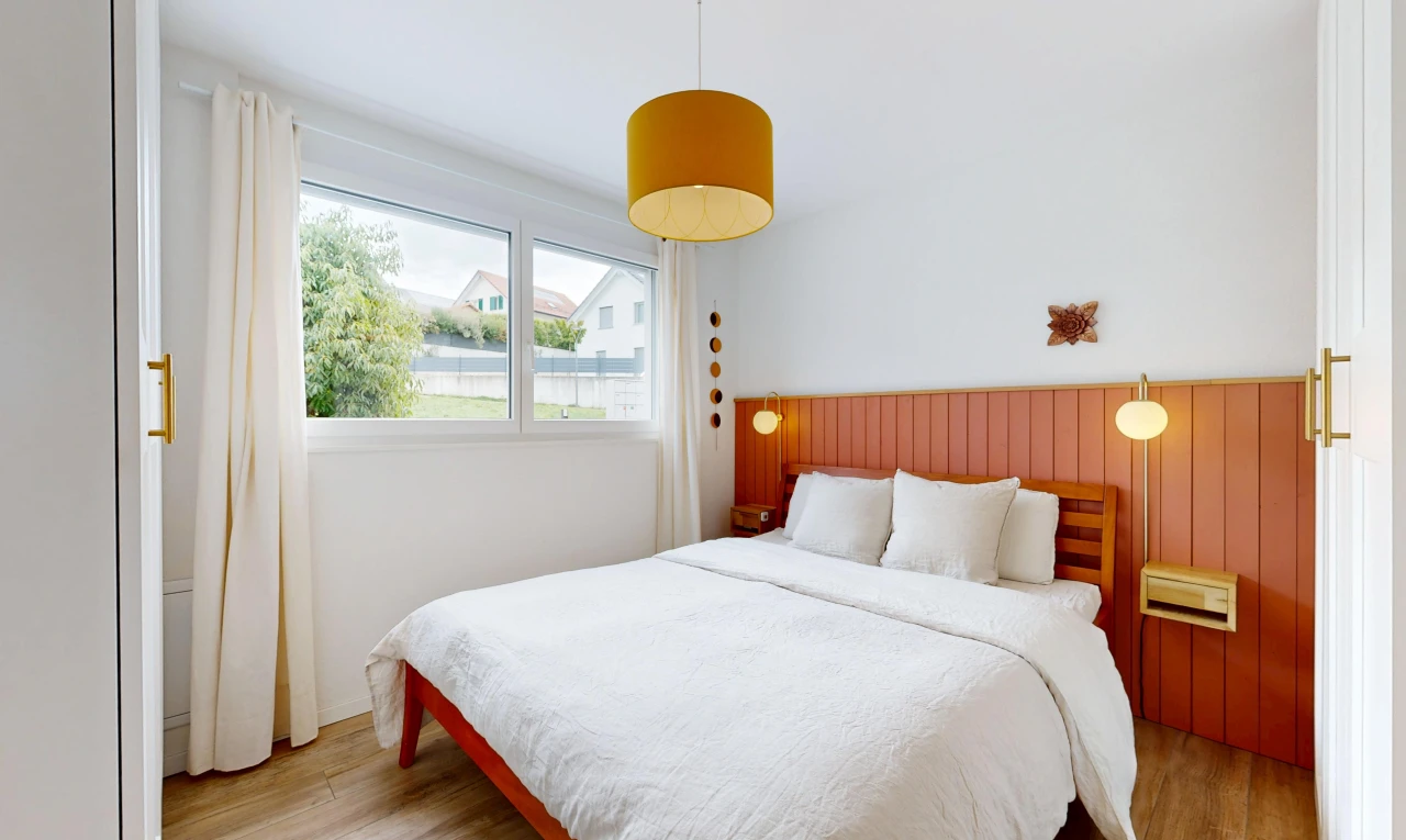 chambre avec éclairage suspendu, cloison sèche, drywall, sol en finition bois, et wood finish floor