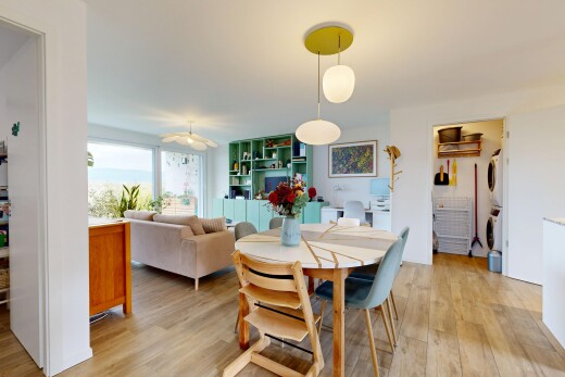 wohn- / esszimmer mit eingebaute regale, waschturm, holzfußboden, wood finish floor, und gipskartonwand