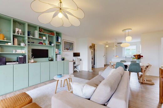 salon / salle à manger avec étagères intégrées, télévision, espace bureau, cloison sèche, et drywall