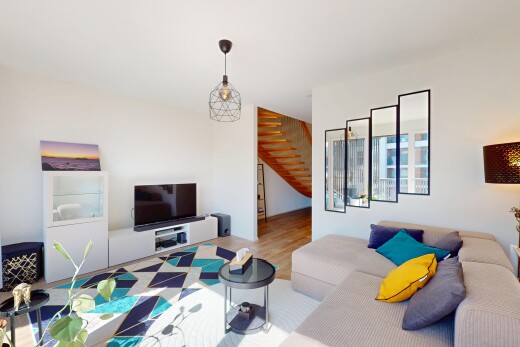 wohnzimmer mit fernseher, holzfußboden, gipskartonwand, und treppen