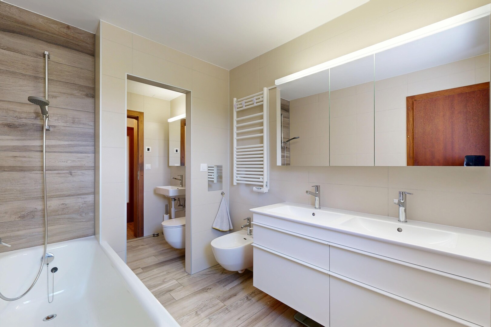 salle de bains avec bidet, chauffe-serviettes, salle de bain complète, light floor, et sol en finition bois