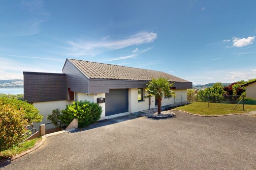 façade avec property visible, bardage en stuc, day time, allée, et garage attaché