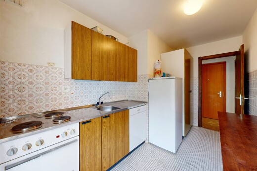 cuisine avec cuisinière, armoires marron moyen, drywall, cloison sèche, et inside property