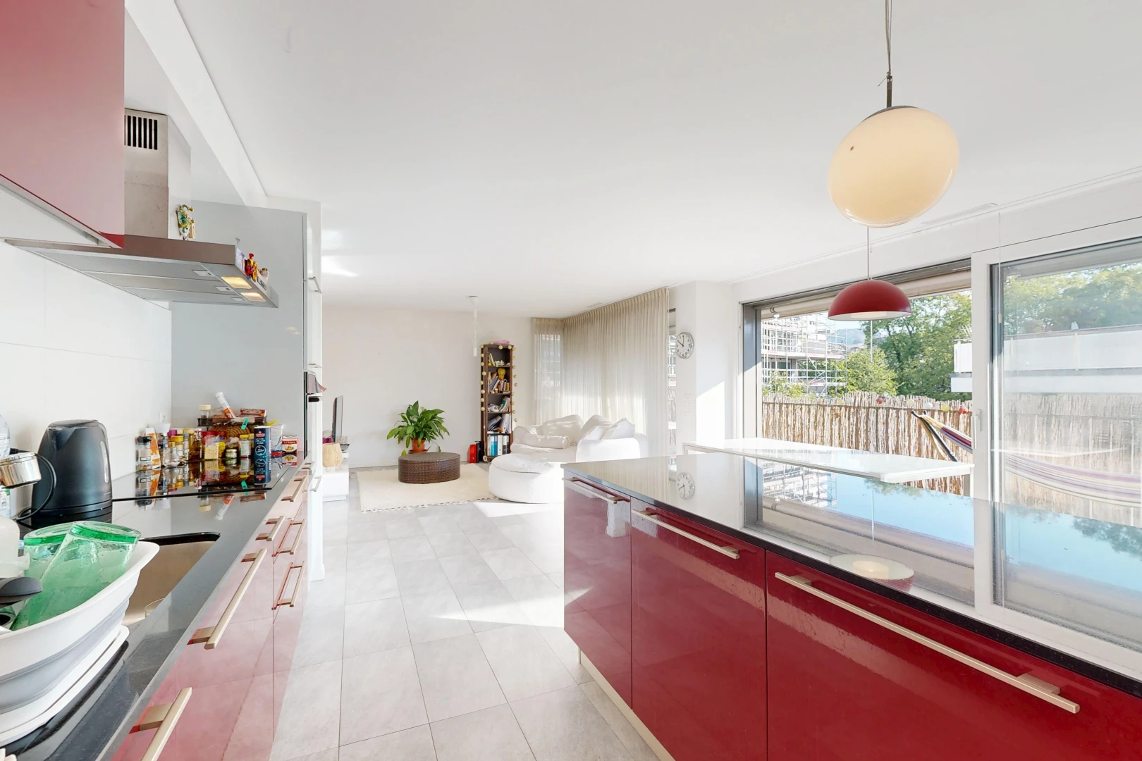 kitchen featuring dark countertops, pendant lighting, open floor plan, modern cabinets, and light tile patterned flooring