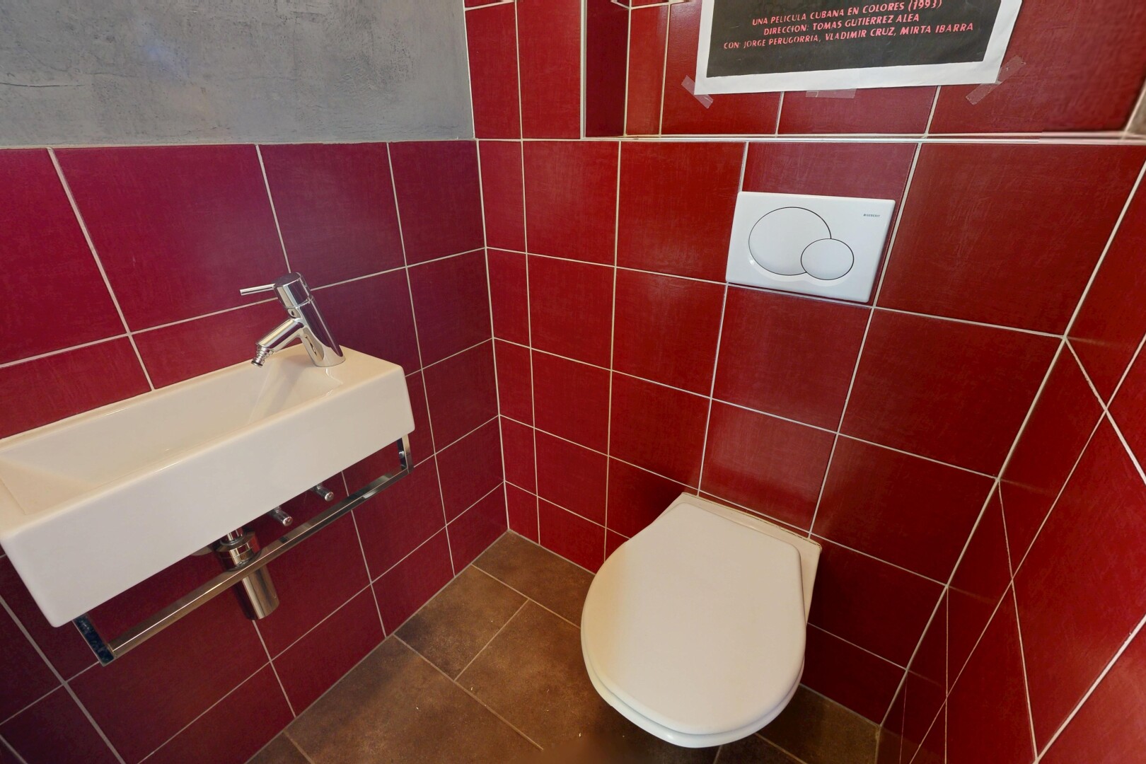 salle de bains avec toilette, tile wall, évier, et inside community