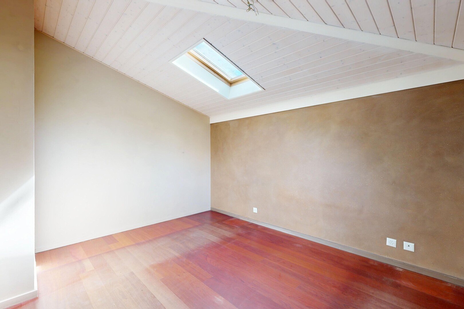 pièce vide avec inside property, wood finish floor, sol en finition bois, vaulted ceiling, et plafond voûté