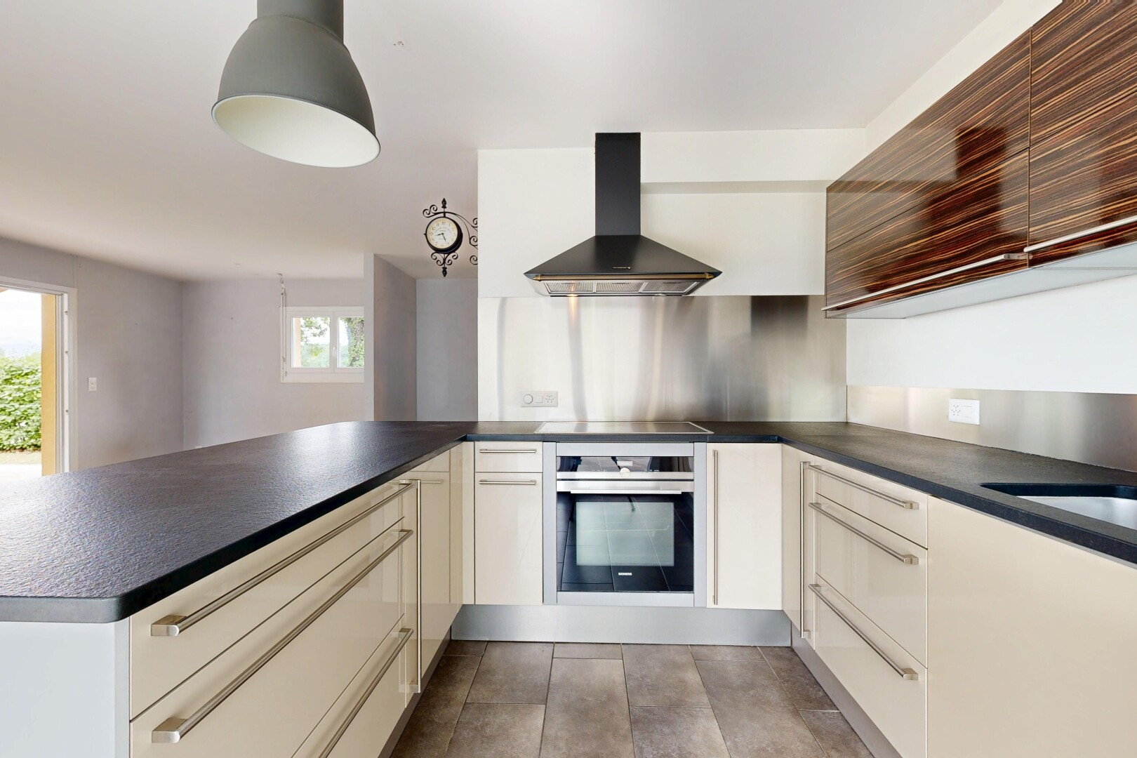 cuisine avec hotte, plans de travail, dark countertops, four, et péninsule de cuisine