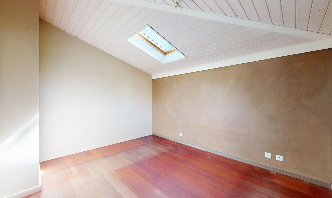 pièce vide avec inside property, wood finish floor, sol en finition bois, vaulted ceiling, et plafond voûté