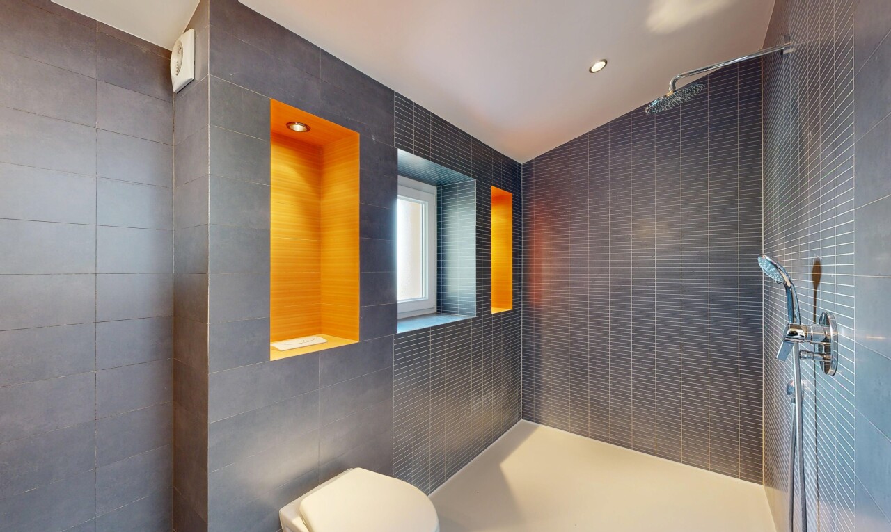 salle de bains avec tile wall, mur en carrelage, vaulted ceiling, plafond voûté, et salle de bain complète